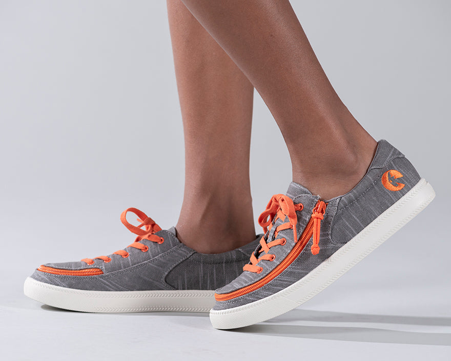 Kid's Grey/Orange BILLY Classic Lace Lows, zipper shoes, like velcro, that are adaptive, accessible, inclusive and use universal design to accommodate an afo. Footwear is medium and wide width, M, D and EEE, are comfortable, and come in toddler, kids, mens, and womens sizing.