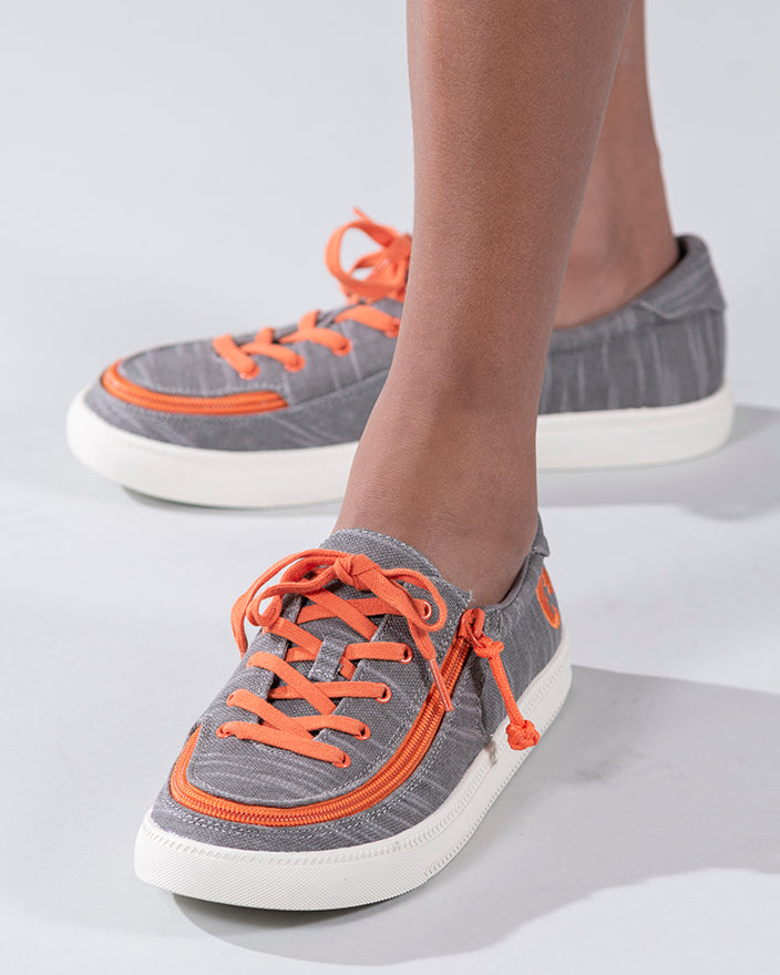 Kid's Grey/Orange BILLY Classic Lace Lows, zipper shoes, like velcro, that are adaptive, accessible, inclusive and use universal design to accommodate an afo. Footwear is medium and wide width, M, D and EEE, are comfortable, and come in toddler, kids, mens, and womens sizing.