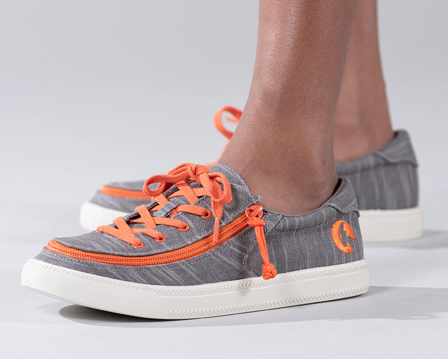 Kid's Grey/Orange BILLY Classic Lace Lows, zipper shoes, like velcro, that are adaptive, accessible, inclusive and use universal design to accommodate an afo. Footwear is medium and wide width, M, D and EEE, are comfortable, and come in toddler, kids, mens, and womens sizing.