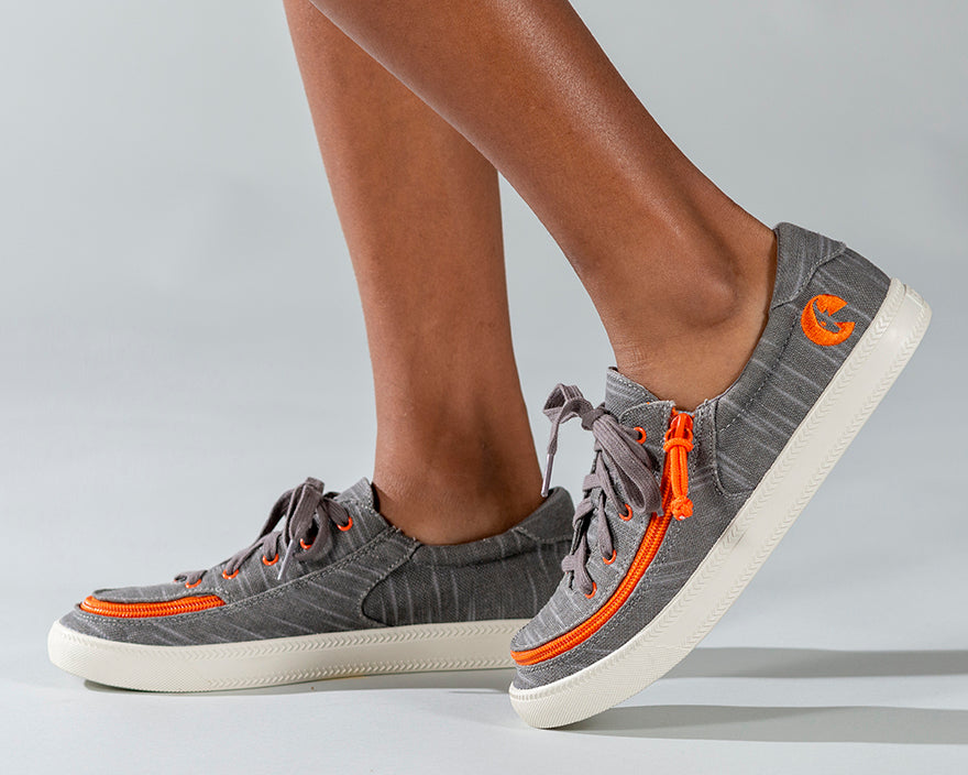 Kid's Grey/Orange BILLY Classic Lace Lows, zipper shoes, like velcro, that are adaptive, accessible, inclusive and use universal design to accommodate an afo. Footwear is medium and wide width, M, D and EEE, are comfortable, and come in toddler, kids, mens, and womens sizing.