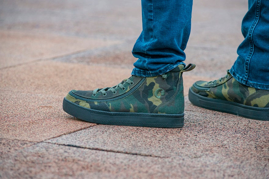Men's Green Camo BILLY Classic Lace Highs, zipper shoes, like velcro, that are adaptive, accessible, inclusive and use universal design to accommodate an afo. Footwear is medium and wide width, M, D and EEE, are comfortable, and come in toddler, kids, mens, and womens sizing.